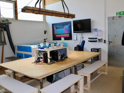 Offene Technikwerkstatt im Kempodium Kempten mit großem Arbeitstisch, Lasercutter und Lötarbeitsplätzen für Technikprojekte mit Kindern, Jugendlichen und Erwachsenen