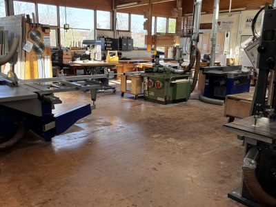 Geräumige Holzwerkstatt im Kempodium Kempten mit Formatkreissäge, Bandsäge, Oberfräse und großem Oberlichtfenster – leer und einsatzbereit für Kurse.