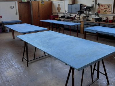 Die helle Kreativ-Werkstatt im Kempodium Kempten. Ausgestattet mit großen, blauen Arbeitstischen, Werkzeugen und Maschinen bietet der Raum Platz für Kinderkurse, Bastel-Projekte und kreative Handwerks-Workshops.
